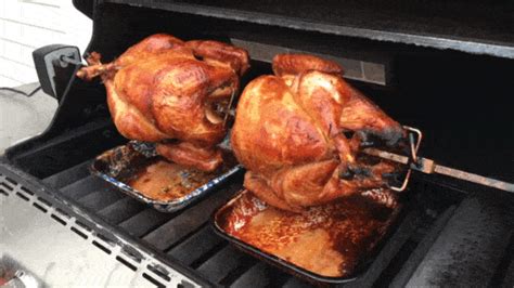 Homemade chicken rotisserie with thyme, lemon closeup on a slate board on the table. . Spitroasted gifs